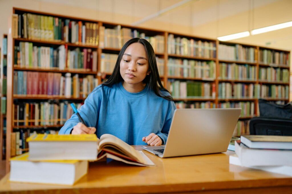 Studente studeert in bibliotheek met laptop